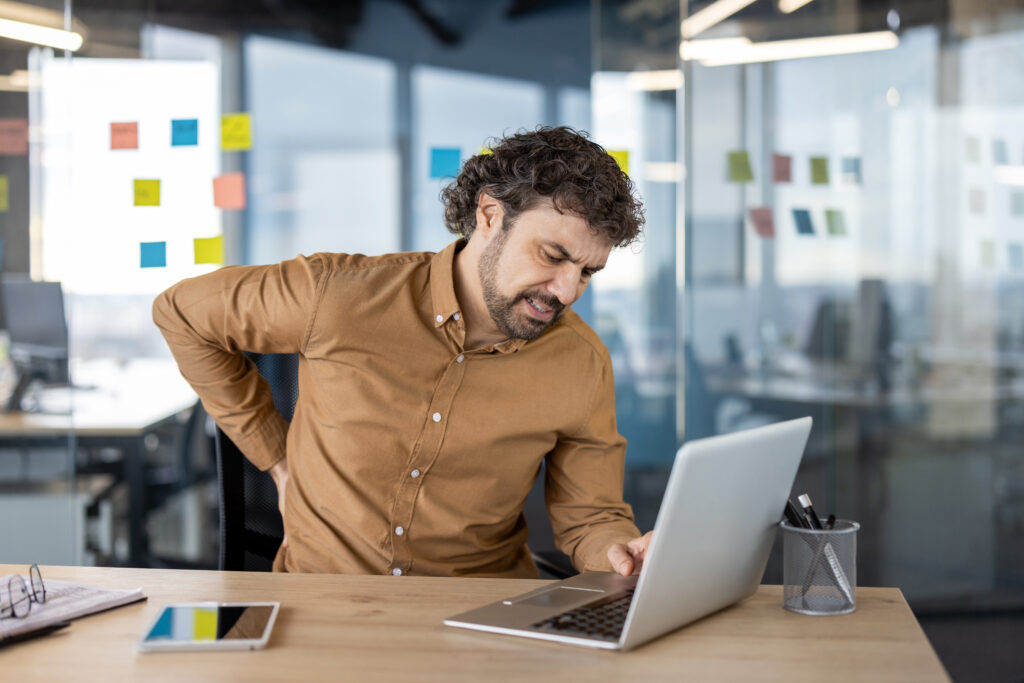 a man with backache looking at a laptop